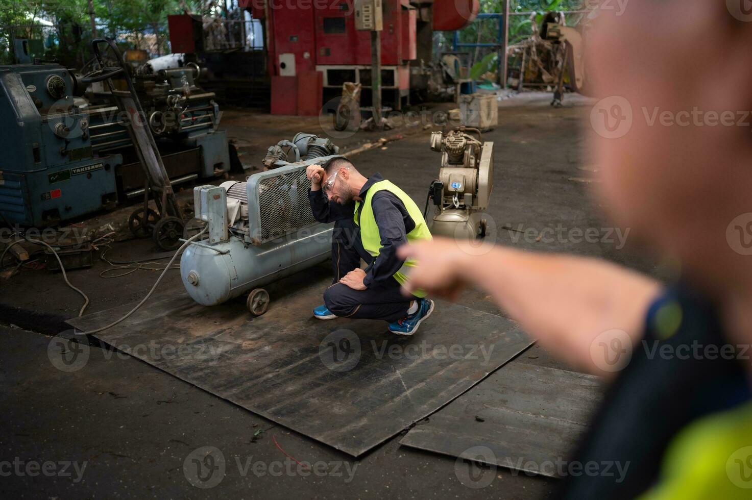 The technician team leader encourages the team who are tired from hard work. in repairing old machinery to return to normal operation in the company's old machinery warehouse photo