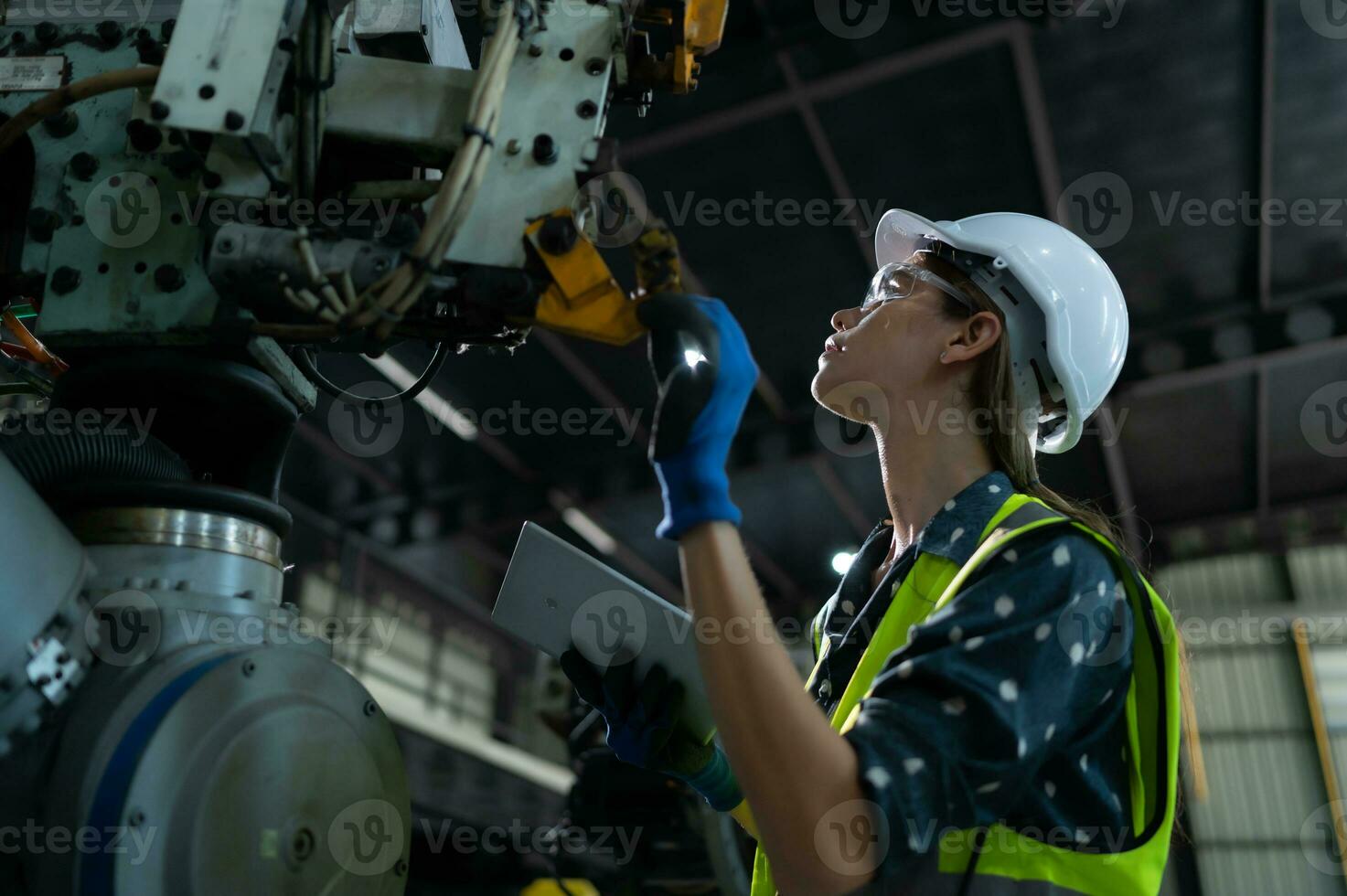 A female engineer installs a program on a robotics arm in a robot warehouse. And test the operation before sending the machine to the customer. photo