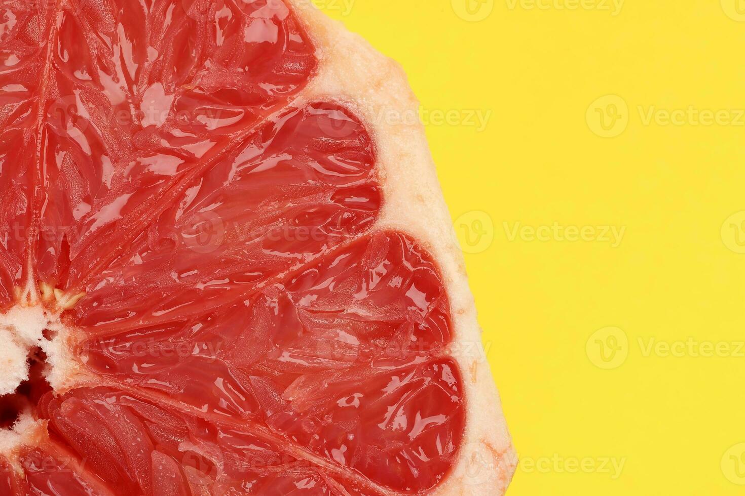 Ruby red grapefruit closeup macro pulp on yellow background photo