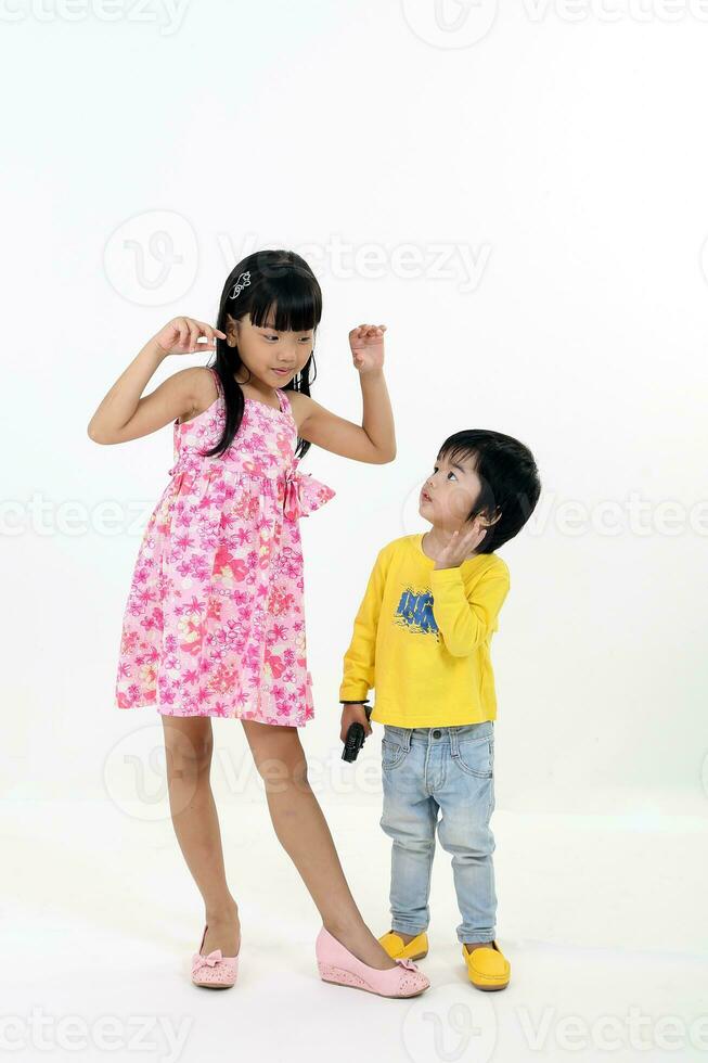 South East Asian young girl boy child brother sister siblings playing happy posing talking hands on white background photo