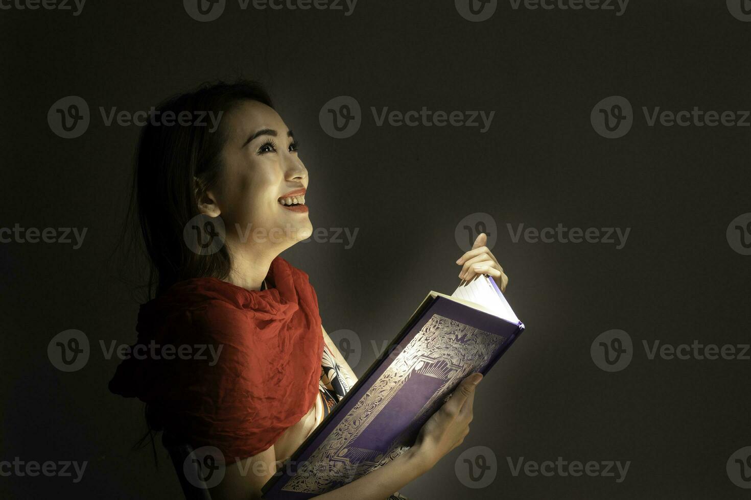 Asian woman opening mystic book box magical light dark background photo