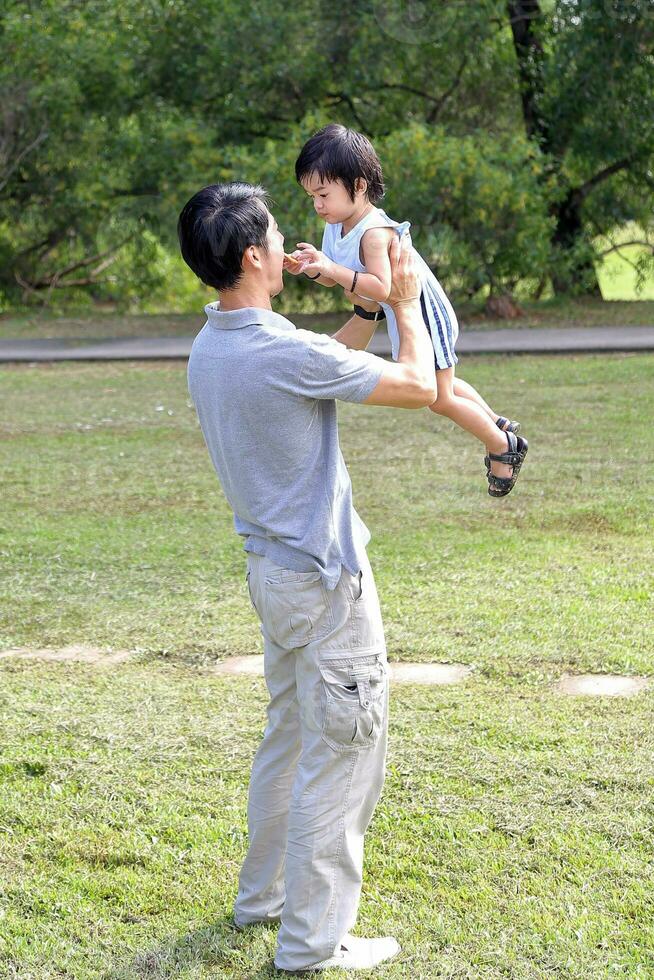 South East Asian young Chinese father son parent child play relax activity outdoor park smile love photo