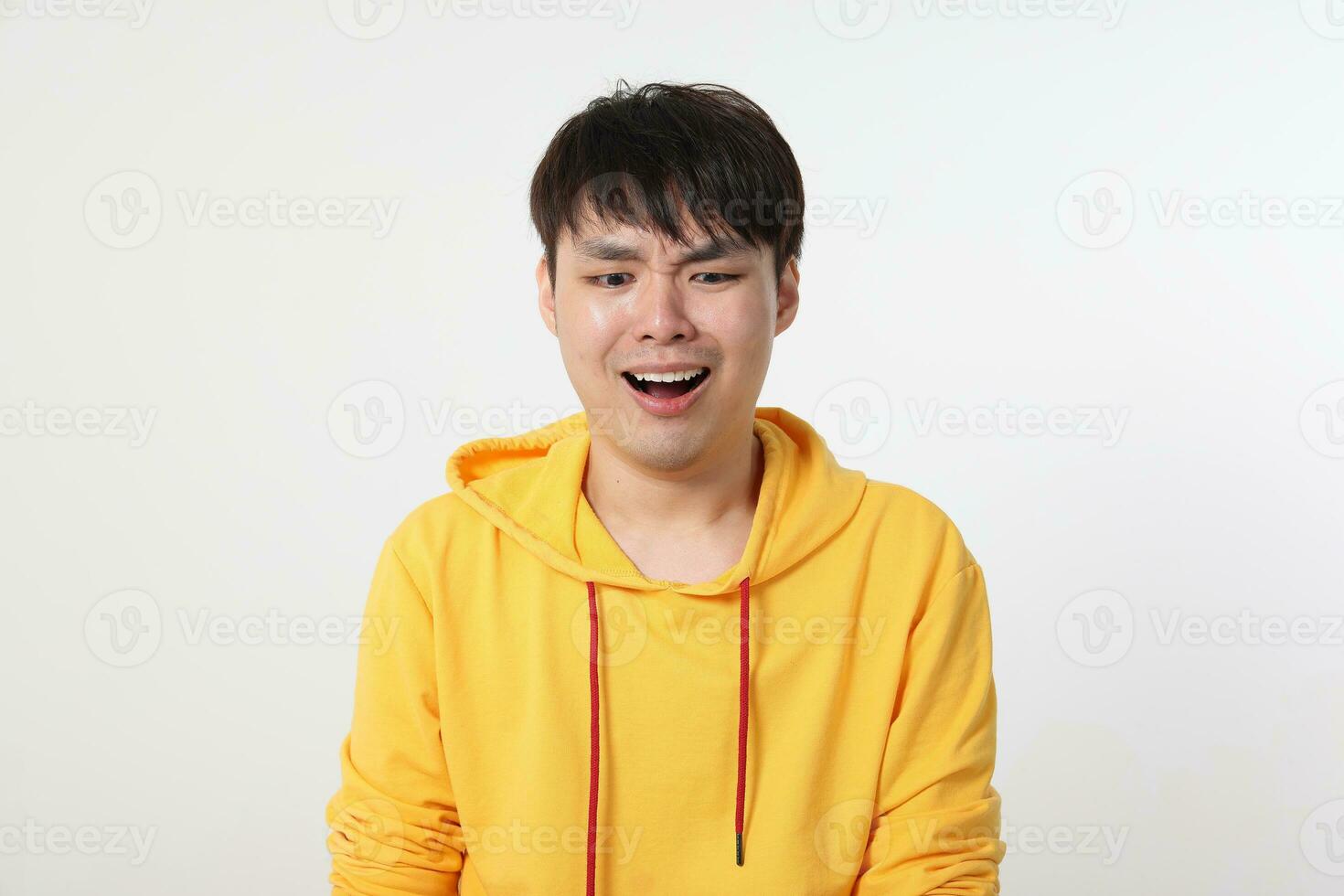 Young good looking Asian chinese malay man pose face body expression mode emotion on white background sad shocked mouth open look down photo