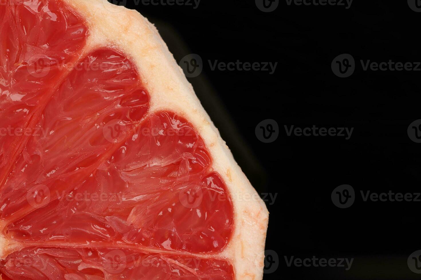 Ruby red grapefruit closeup macro pulp on black background photo