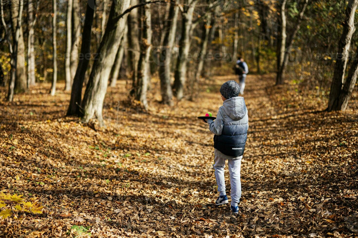 Autumn outdoor portrait of boy with catch and toss ball game. photo