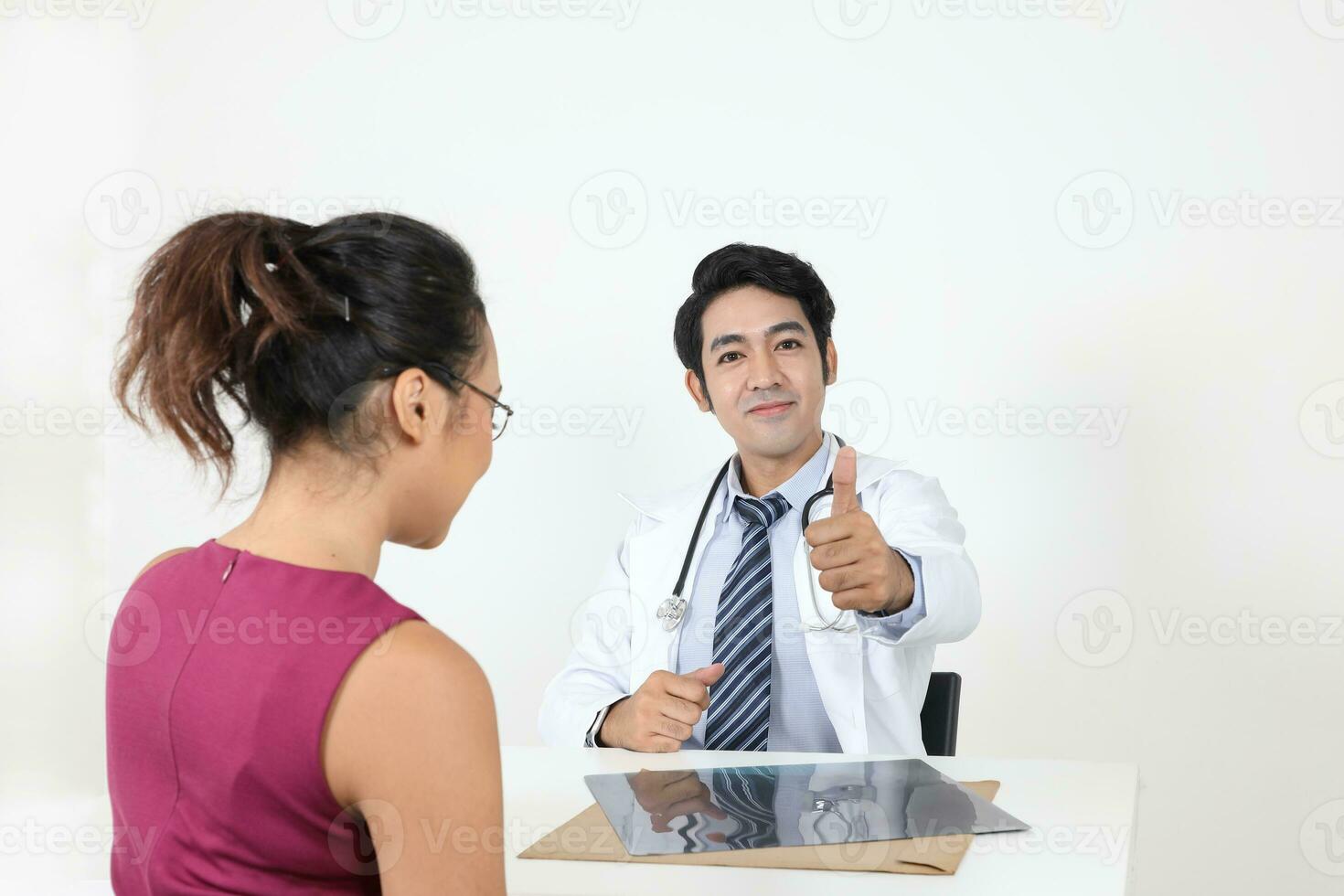 Male doctor female patient discussion consultancy on white background x ray tablet check up happy thumbs up photo