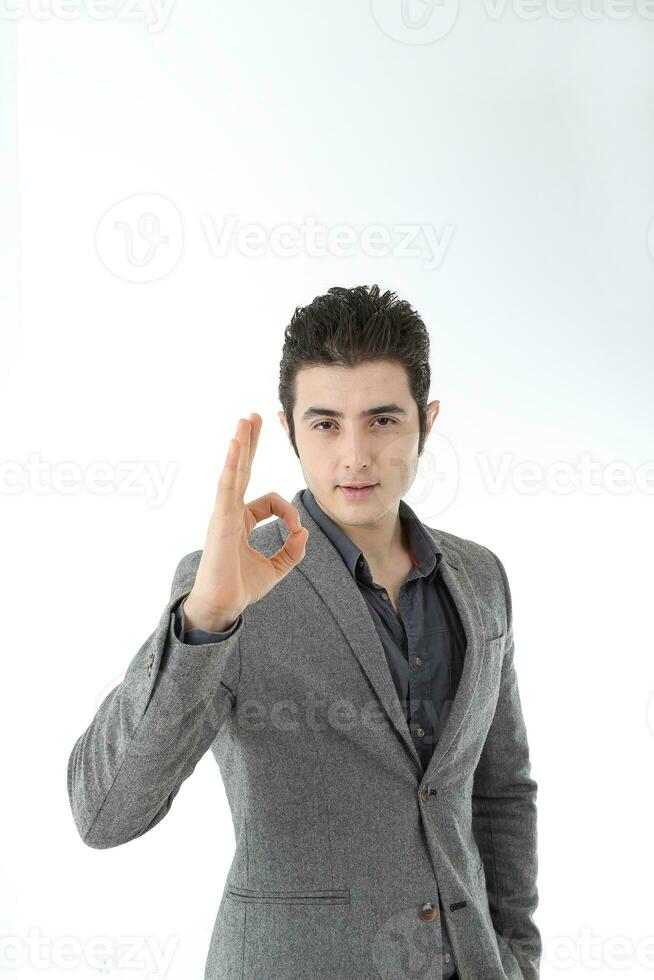 Middle eastern Caucasian young office business man wearing suit ok finger sing look at camera on white studio background photo