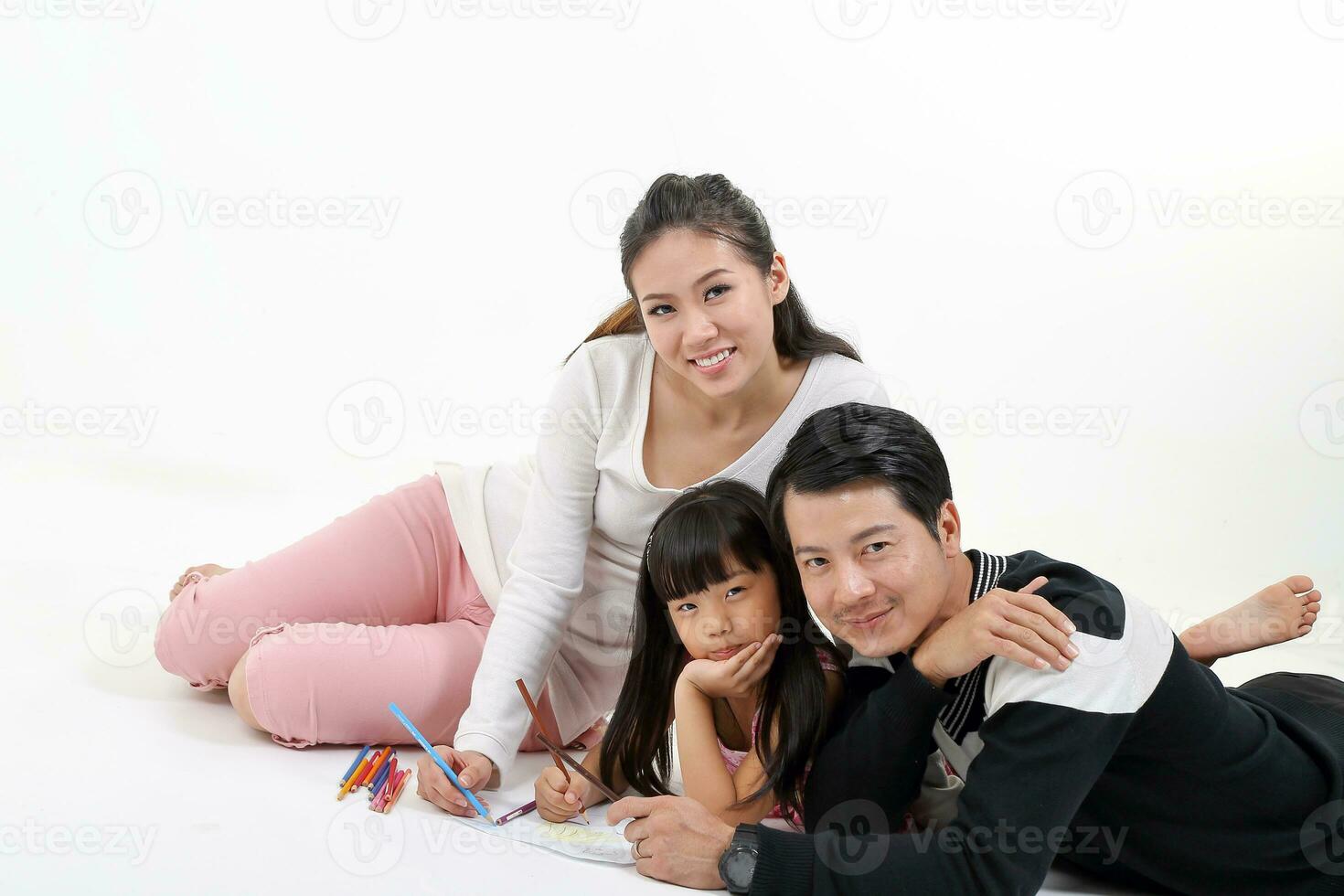 South East Asian father mother daughter parent child study read write look at camera on floor white background pencil paper photo
