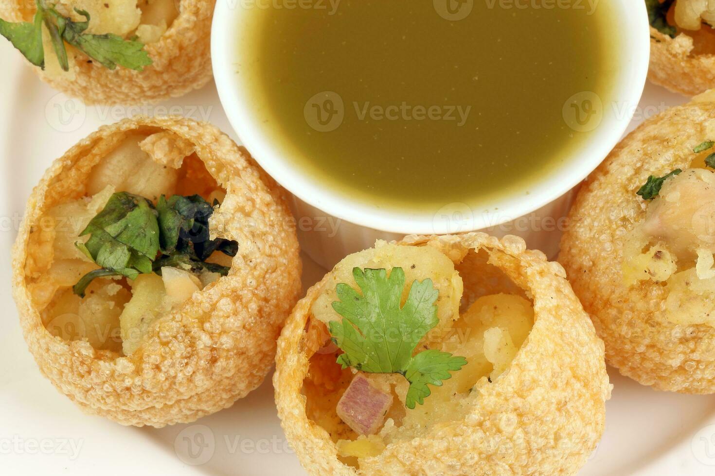 Tadeonal subcontinental street snack food chickpeas potato pani puri fuska with tamarind sauce photo