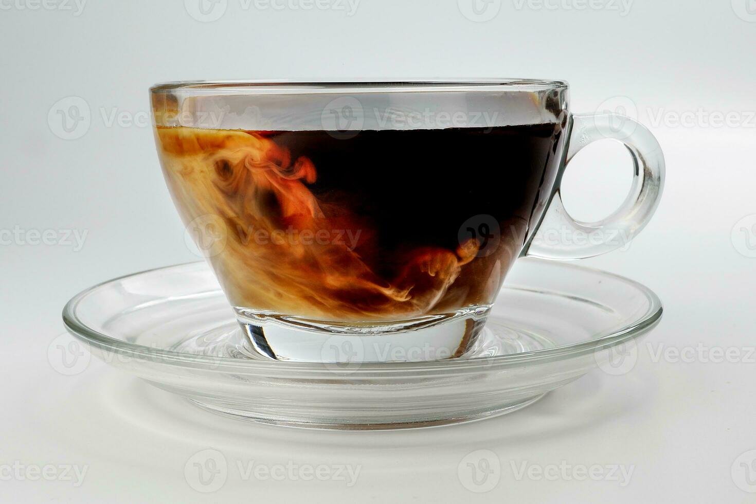 dark Coffee poring white milk dripping splash shadow liquid swirl in glass cup saucer on white background photo