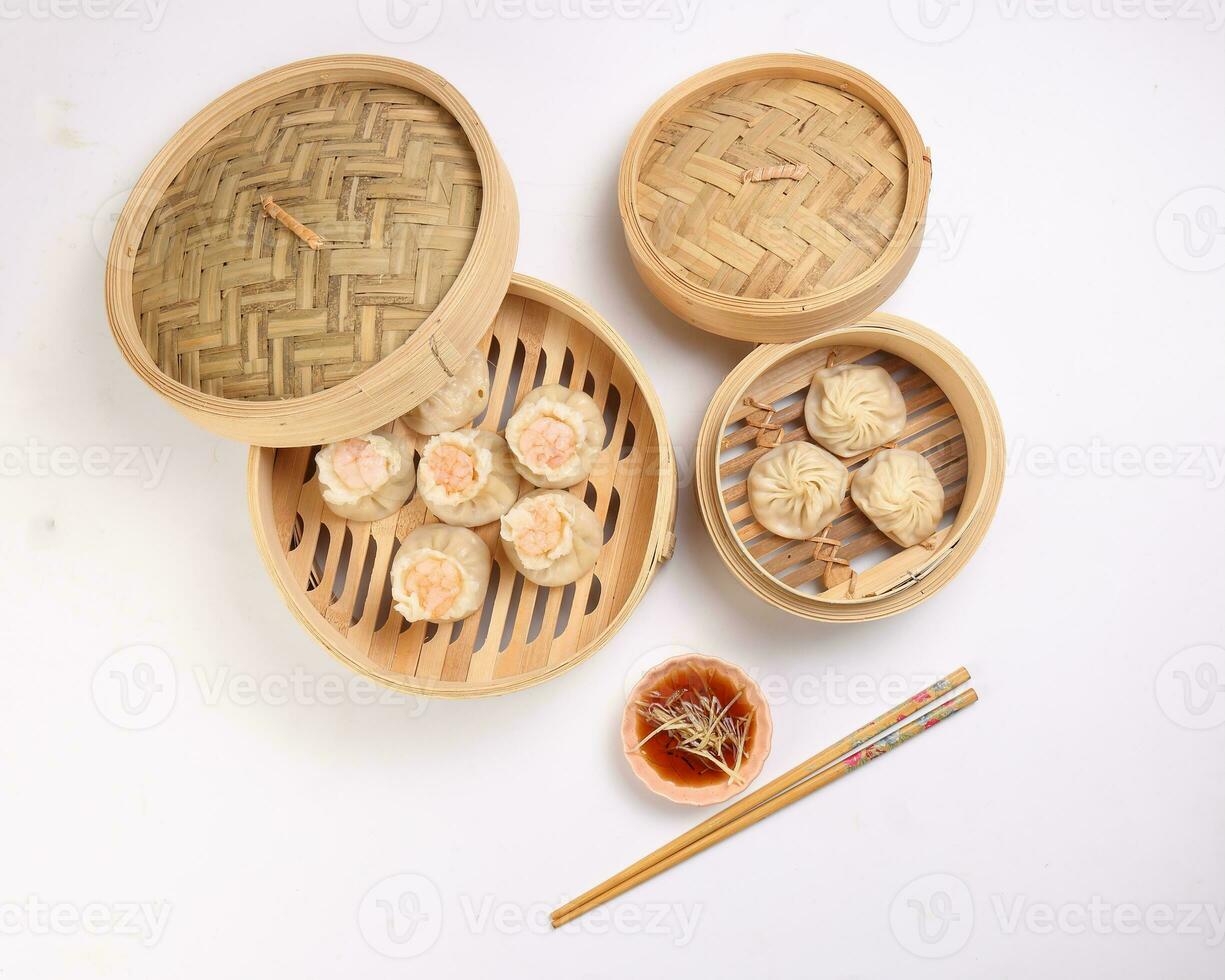 Prawn shrimp shaomai Xiao long bao dim sum dumpling chicken prawn fish seafood vegetable in bamboo steamer sauce chopsticks on white background photo