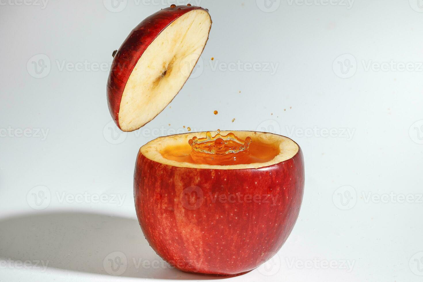 Red Apple real juice splash in fresh half cut hollow cup fruit photo