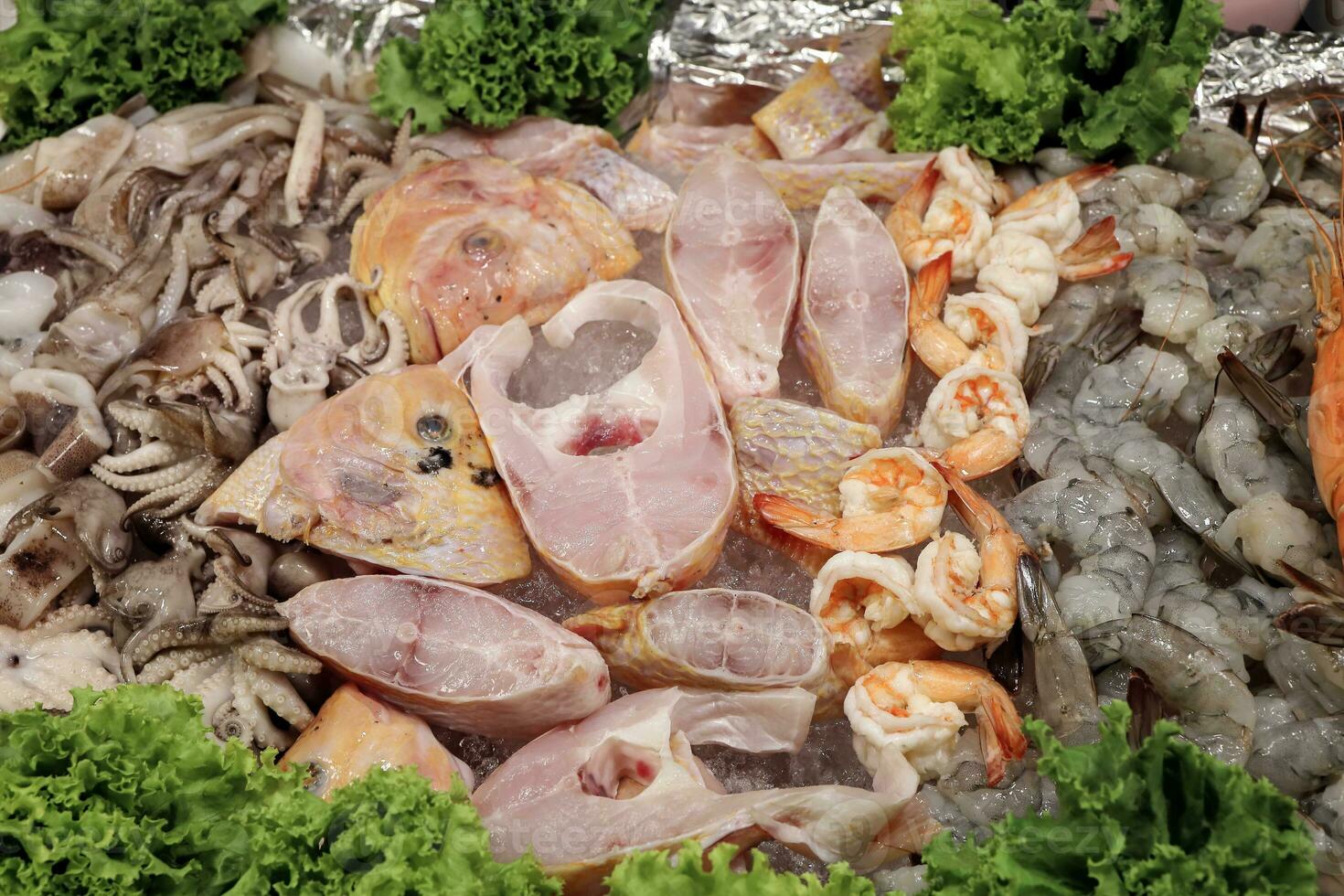 cut clean ready to cook fish prawn shrimp seafood cuttlefish crab on ice at street side food stall photo