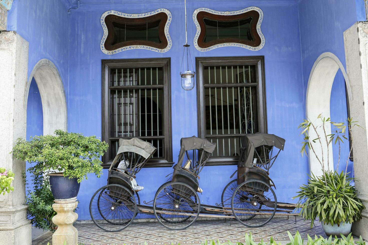 George Town, Penang, Malaysia  June 5, 2019 Cheong Fatt Tze, The Blue mansion was built at the end of 19th century by Chinese merchant. pulled rickshaw at the entrance. photo