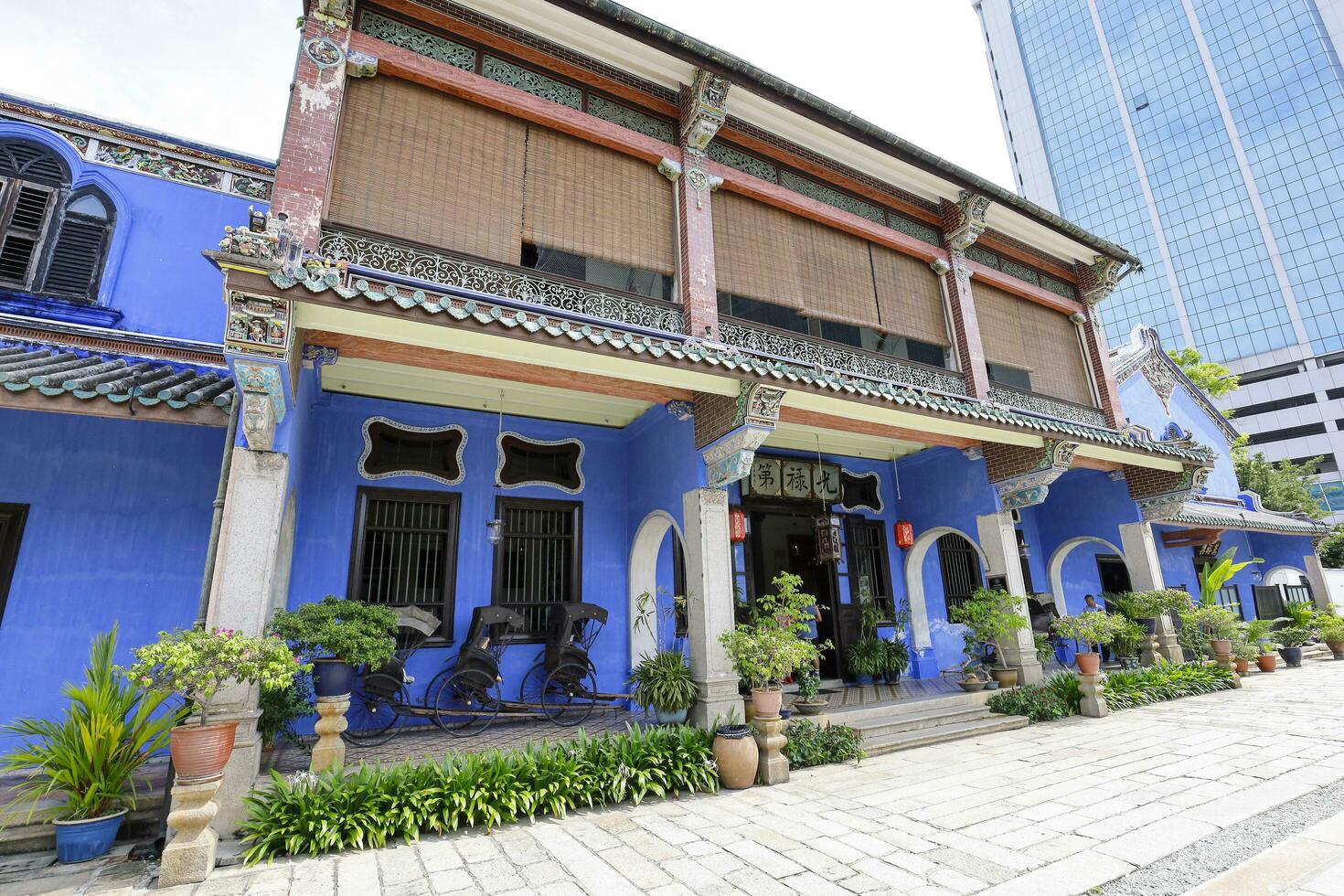 George Town, Penang, Malaysia  June 5, 2019 Cheong Fatt Tze, The Blue mansion was built at the end of 19th century by Chinese merchant. pulled rickshaw at the entrance. photo