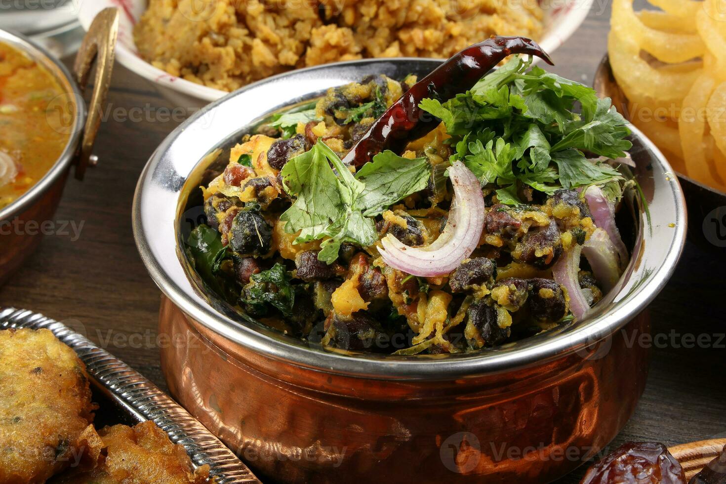 Bengali Iftar Ramadan breakfast spread ripe dates peep fried spicy piaju onion fitter eggplant tanpura potato chop haleem jilapi khichuri rice chana sola curry on rustic wooden table photo