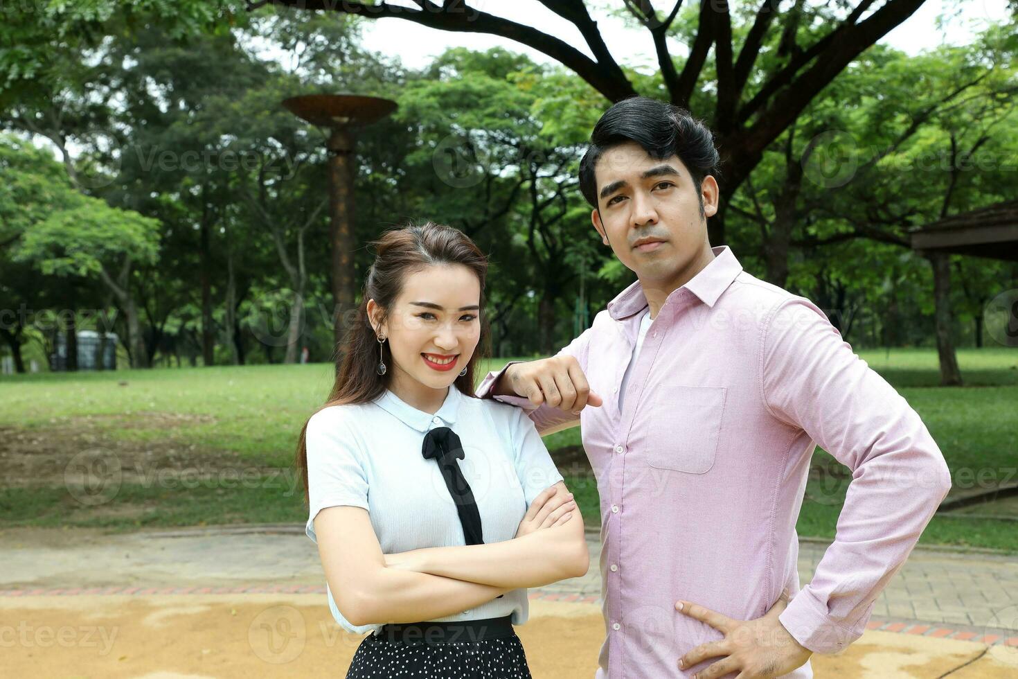 young asian malay chinese man woman outdoor park walk stand study talk discuss laptop file book backpack pose look forward photo