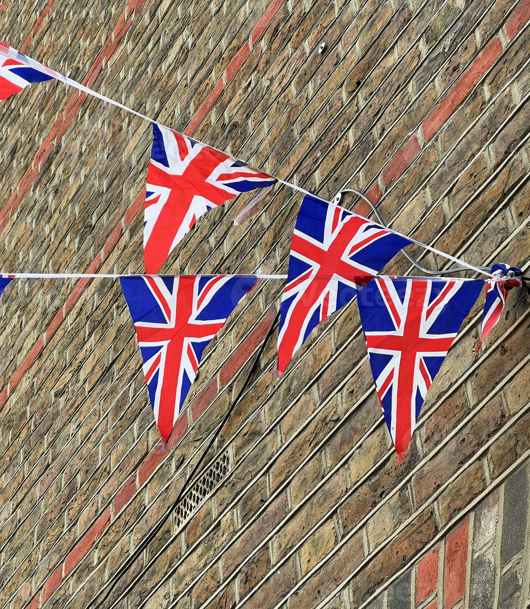 British Union Jack flags hanging at the street against brick wall