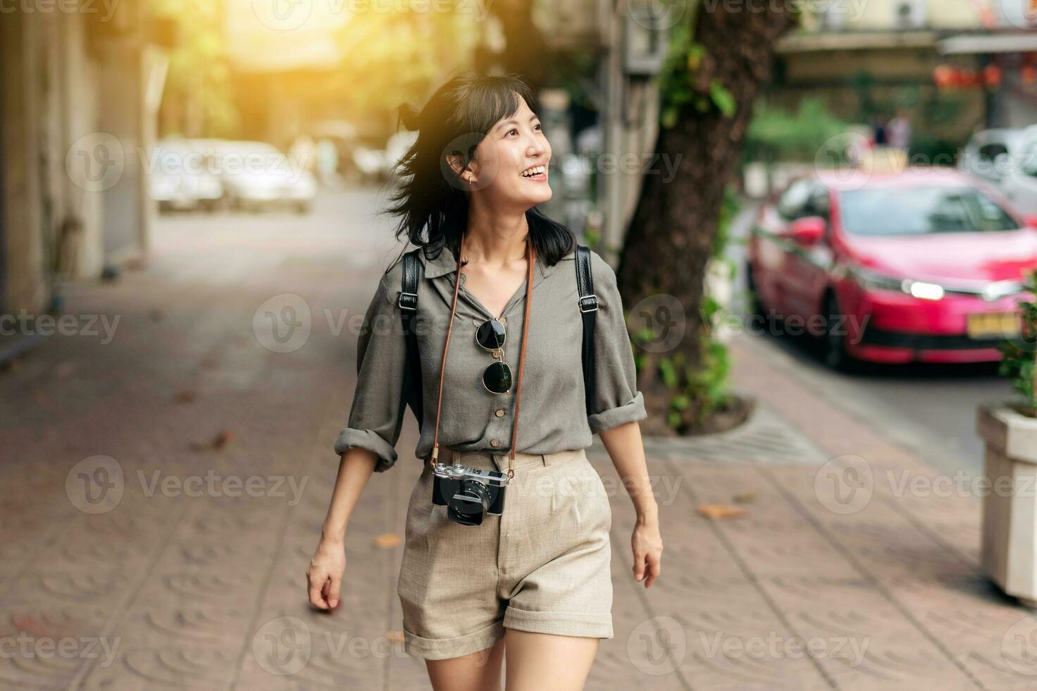 Young Asian woman backpack traveler enjoying street cultural local place and smile. Traveler checking out side streets. photo