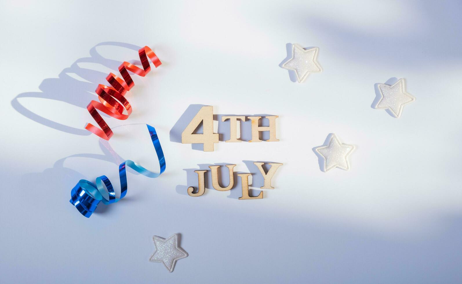 USA Independence day concept. Red and blue spirals and white stars elements of USA flag top view, flat lay on blue background photo