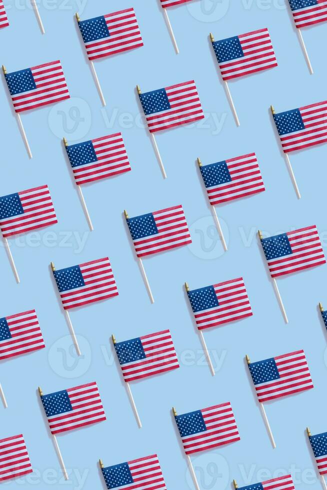 Independence day concept with USA flags pattern top view, flat lay on blue background photo