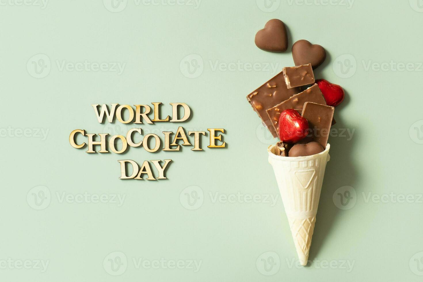 World chocolate day text with chocolate flat lay, top view on pastel green background photo