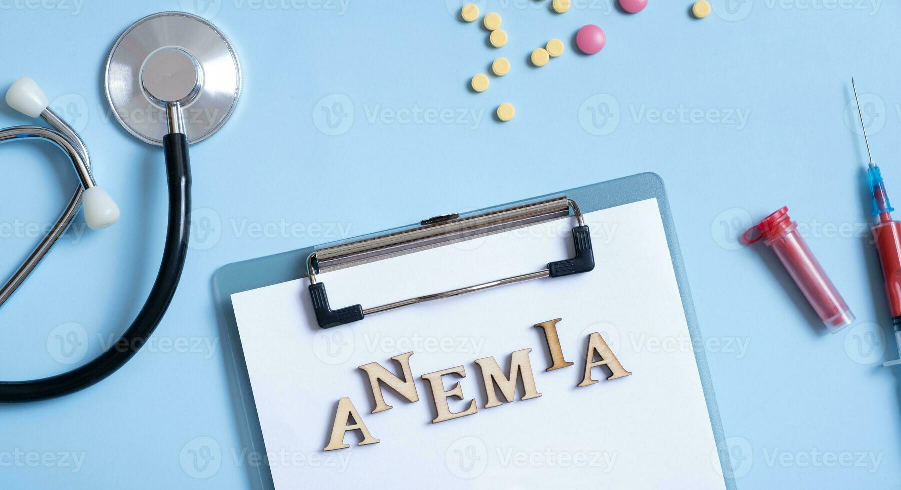 Anemia text with stethoscope, pills and syringe flat lay, top view. Banner format photo