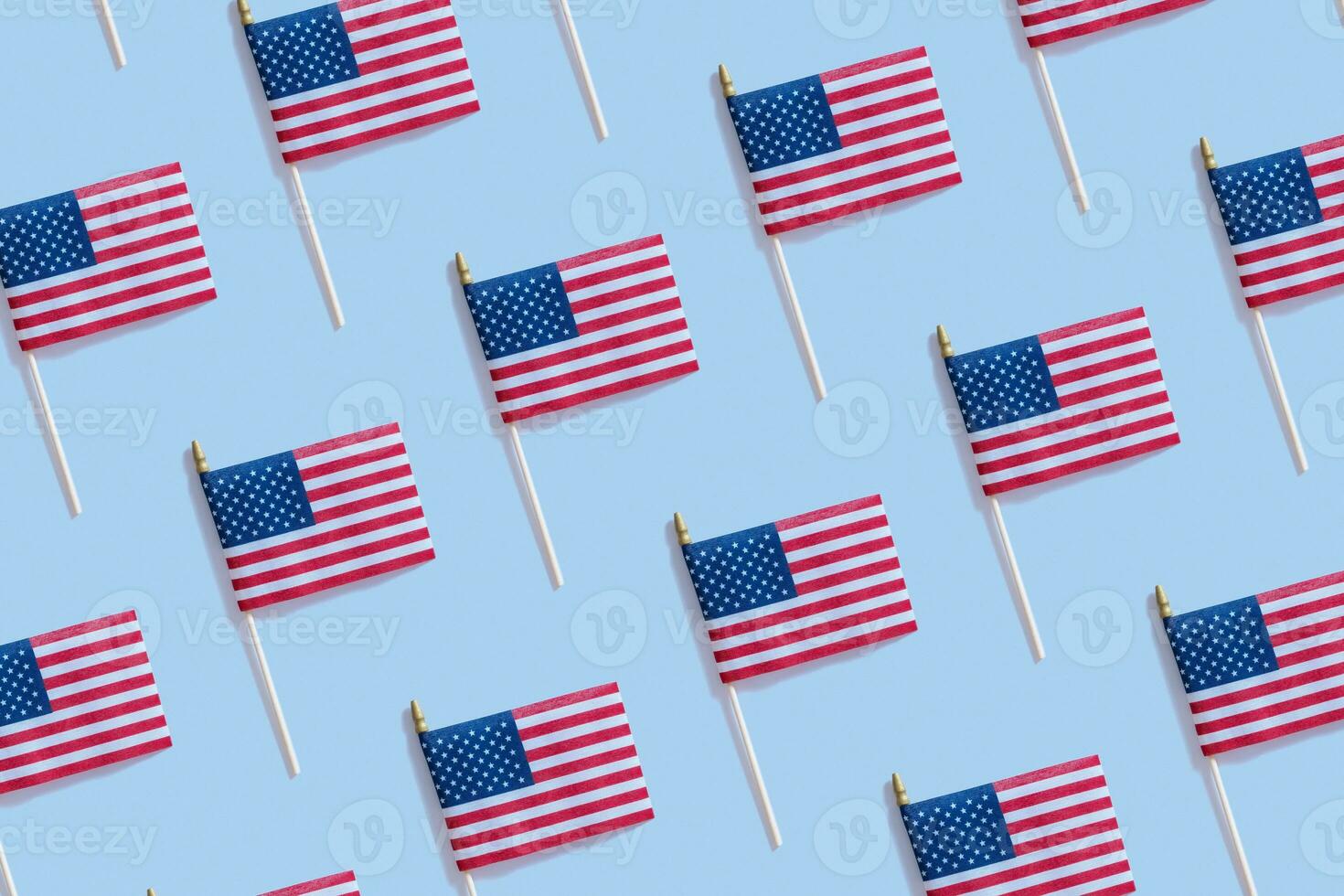 Independence day concept with USA flags pattern top view, flat lay on blue background photo