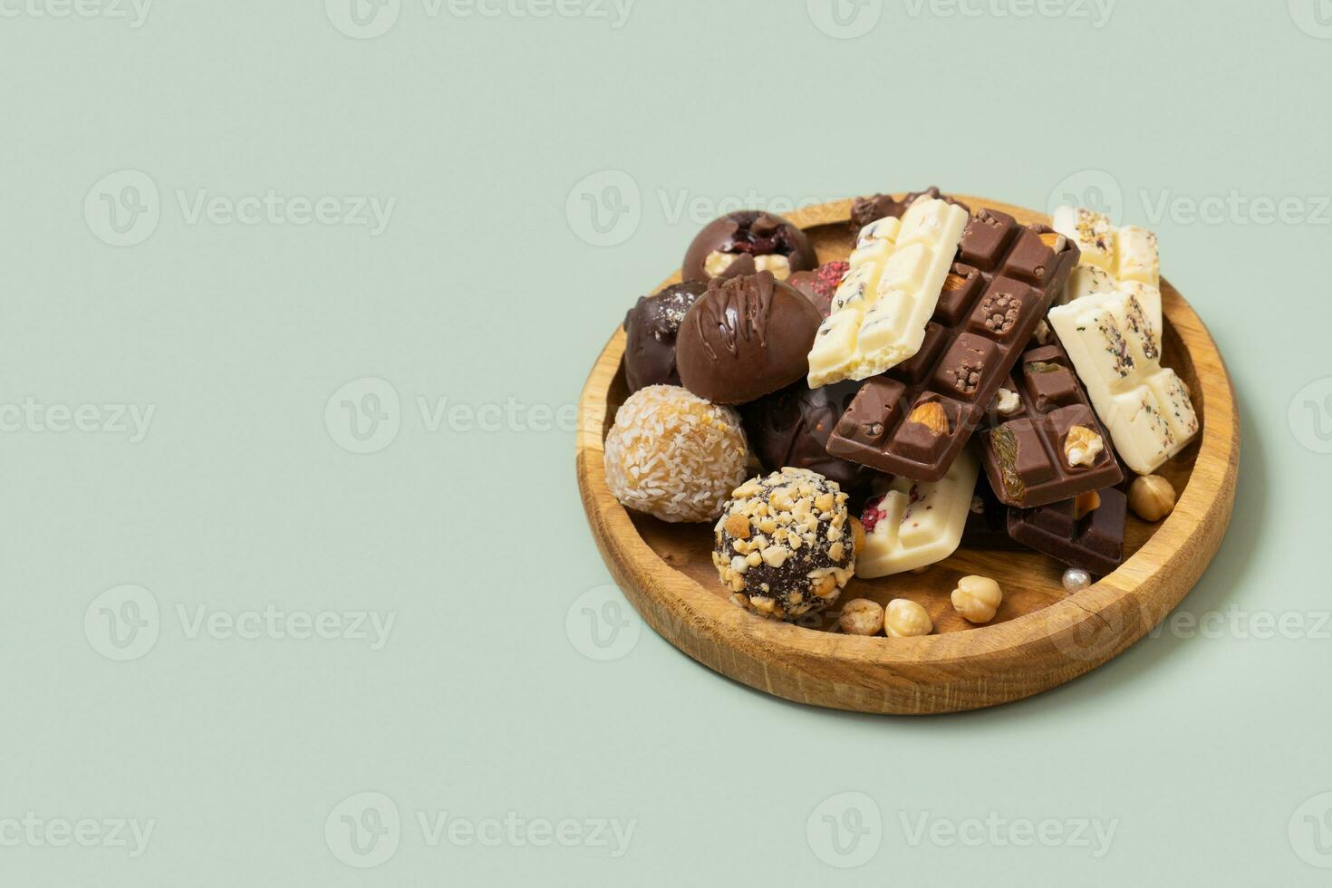 Wooden plate with healthy craft natural candies and mini chocolates. Sweet food, healthy dessert photo