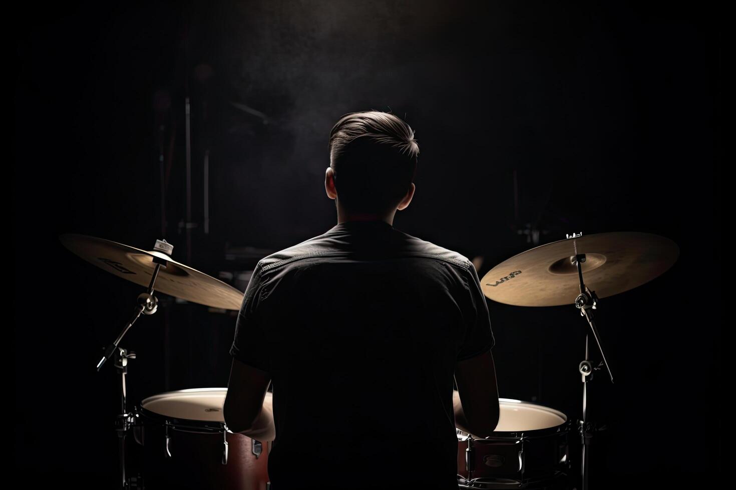 Young man playing drums on a dark background, back view. Music concept, A drummer full rear view playing drums, photo