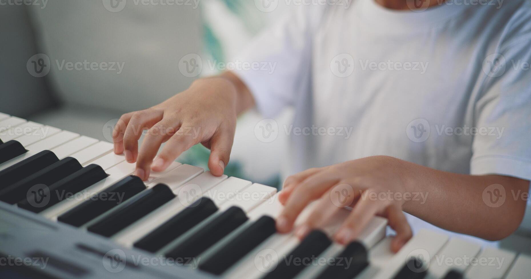 Cute boy enjoy to learning playing piano at home photo