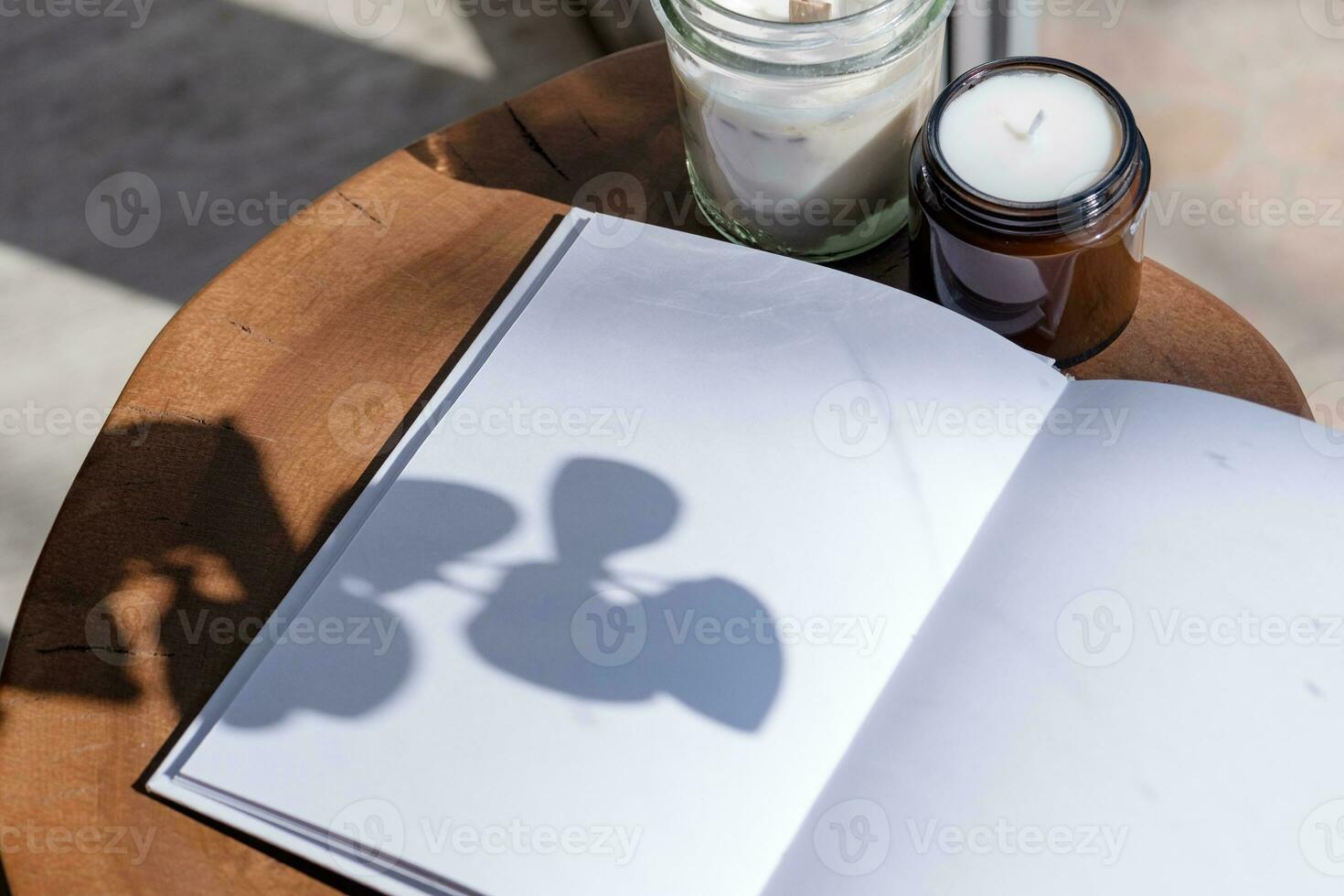 Magazine and book mockup design. Blank magazine on modern wooden table with candles , shadow overlay photo