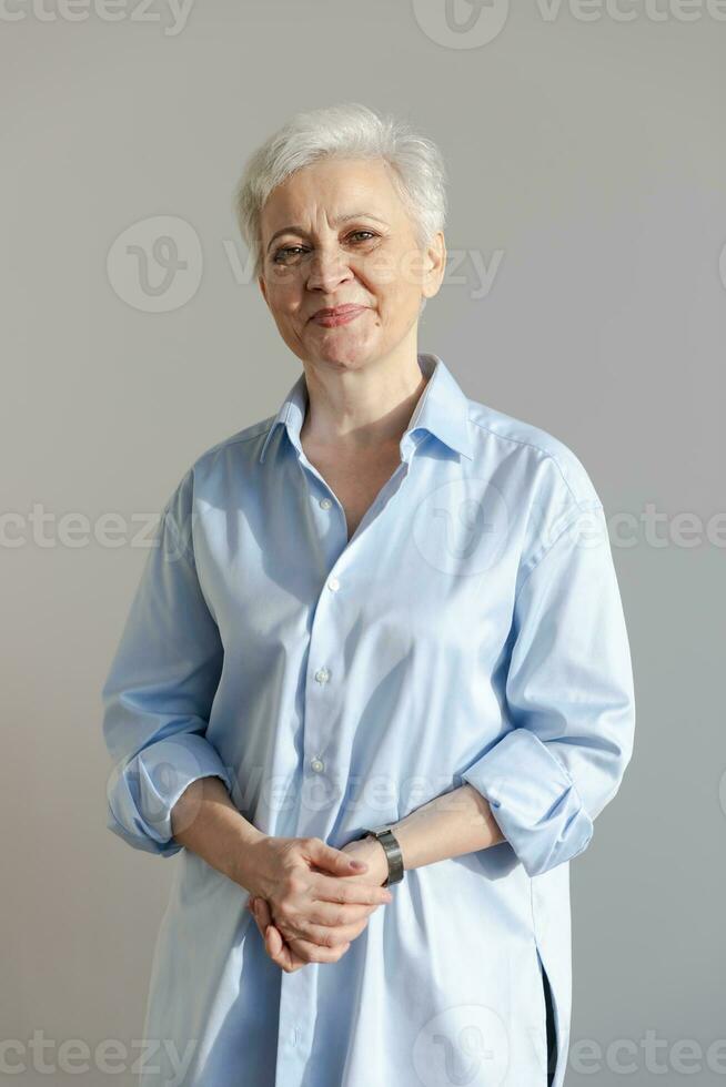 Confident stylish european middle aged senior woman. Older mature 60s lady smiling in white background. Happy attractive senior female looking camera close up face headshot portrait. Happy people. photo