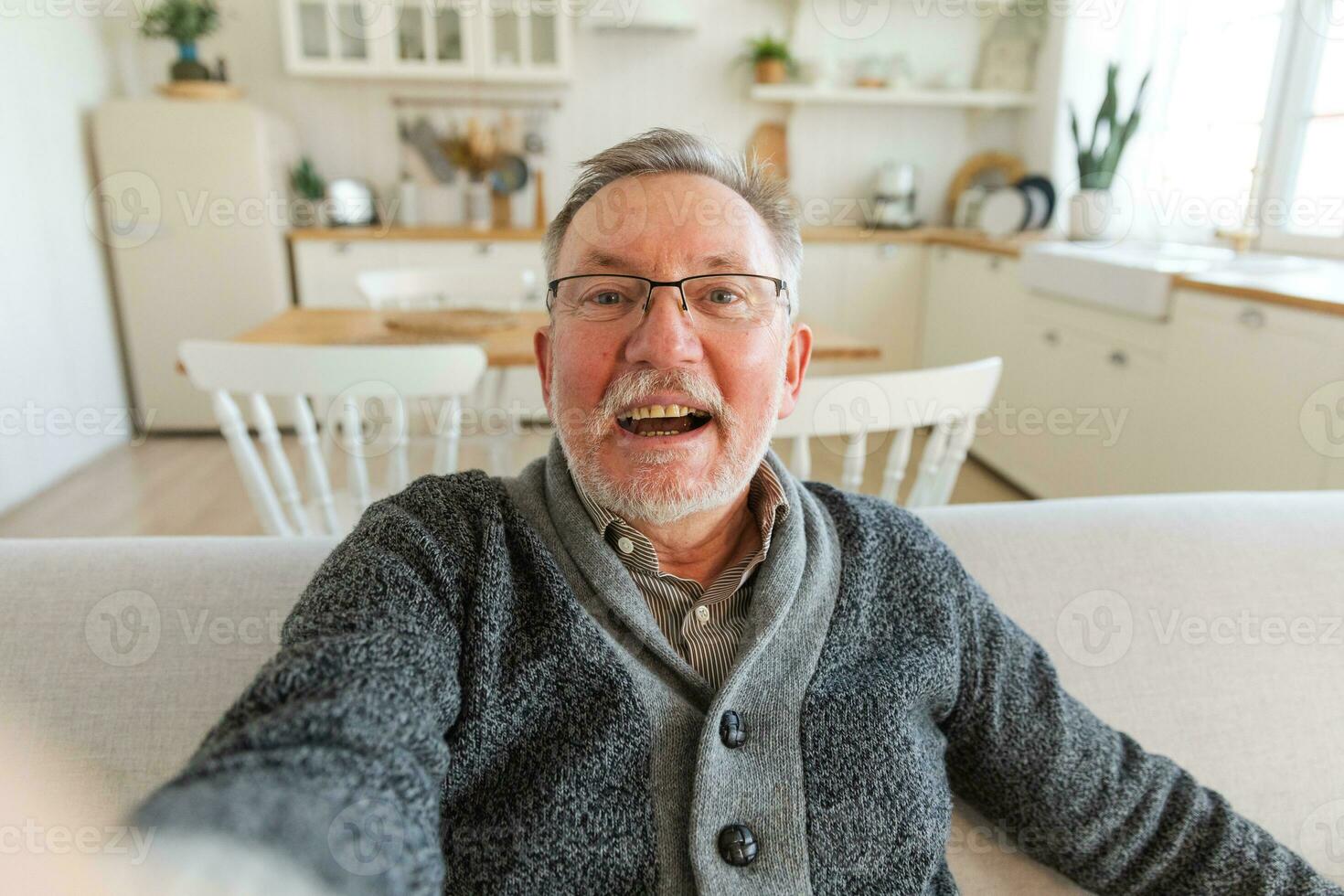 Happy middle aged senior man talk on video call with friends family. Laughing mature old senior grandfather having fun speaking with grown up children online. Headshot portrait selfie webcamera view. photo