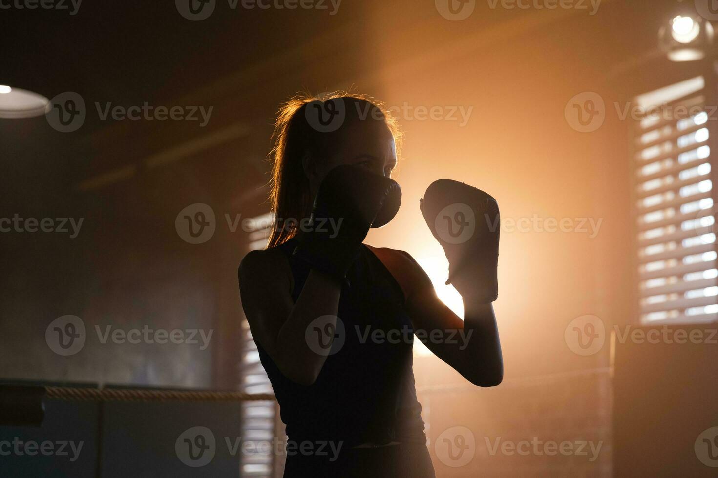 Women self defense girl power. Strong woman fighter training punches on boxing ring. Healthy strong girl punching boxing bag. Training day in boxing gym. Strength fit body workout training. photo