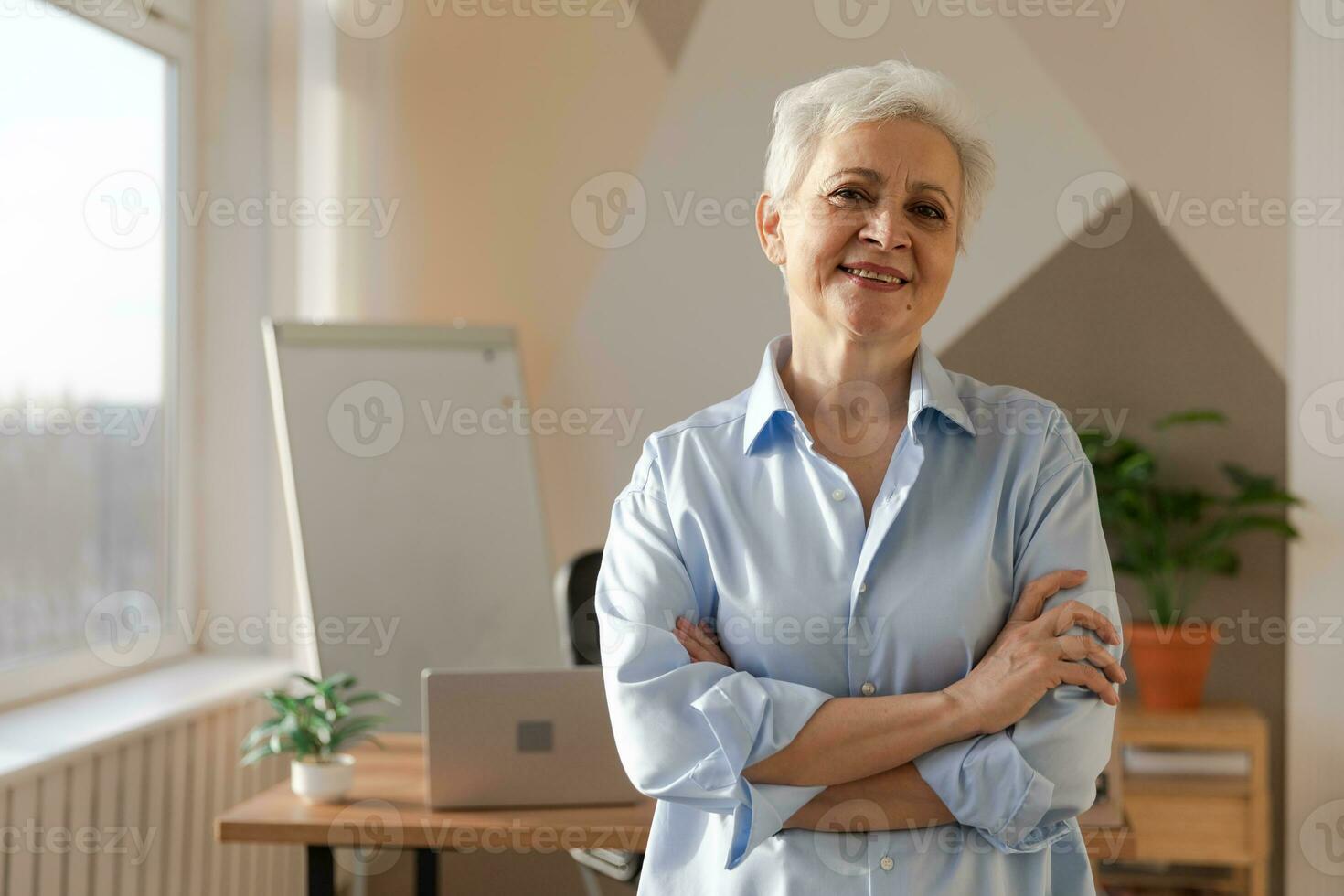 retrato de confidente elegante europeo medio Envejecido mayor mujer a lugar de trabajo. elegante más viejo maduro 60s gris peludo dama mujer de negocios en moderno oficina. jefe líder profesor profesional obrero. foto