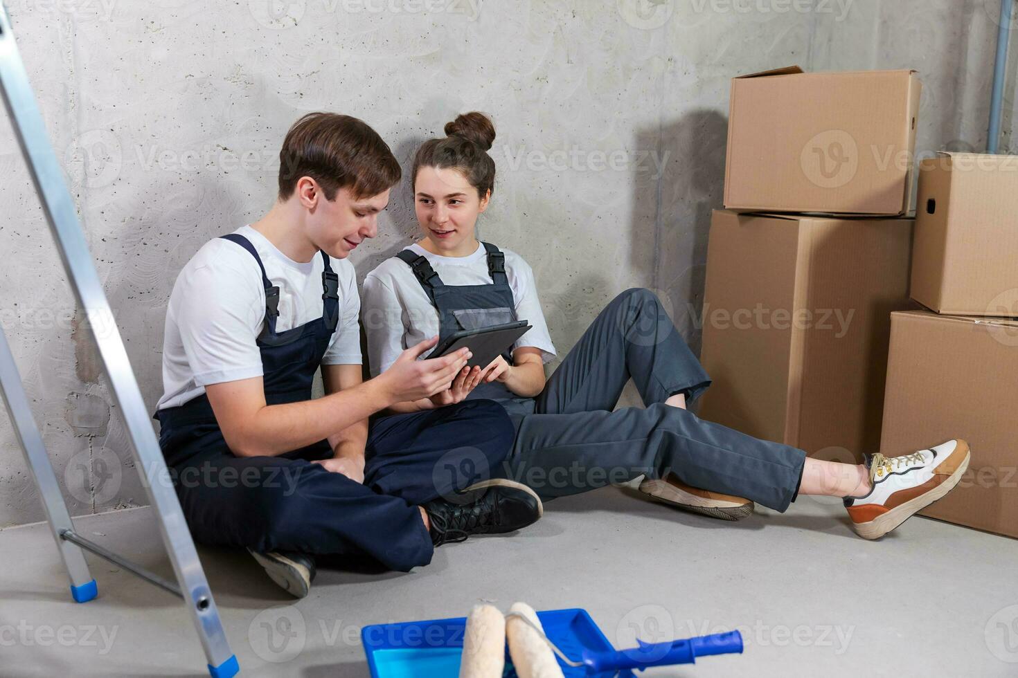 Couple in new home during repair works discussing about home design project looking repair plan on tablet. Happy family choosing new decorations and design. Home renovation DIY renew makeover concept. photo