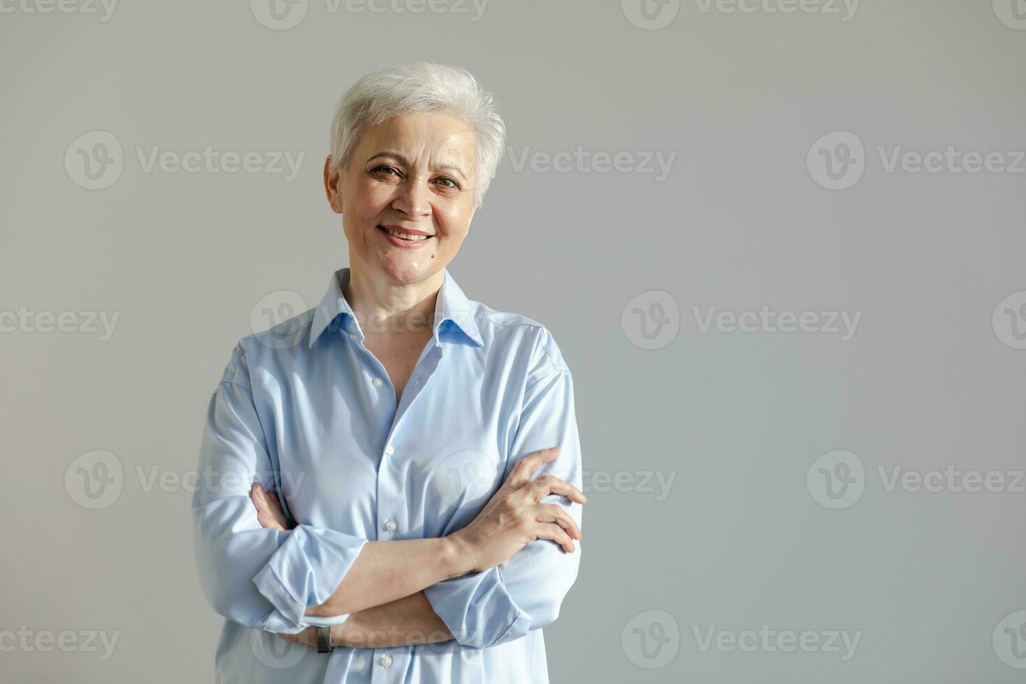 Confident stylish european middle aged senior woman. Older mature 60s lady smiling in white background. Happy attractive senior female looking camera close up face headshot portrait. Happy people. photo