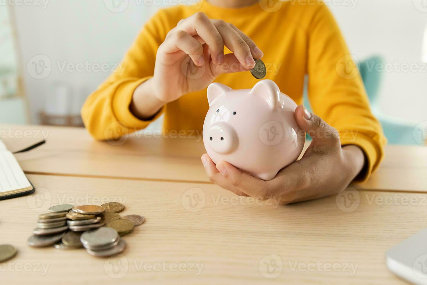 Saving money investment for future. African american girl holding pink piggy bank and putting money coin. Saving investment budget business wealth retirement financial money banking concept. photo