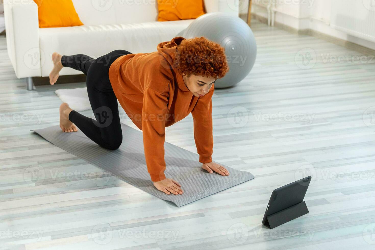 Fitness Workout training. Young healthy fit african girl doing sports exercise on yoga mat on floor at home. Athletic woman in sportswear have training workout for weight loss. Sport and fitness. photo