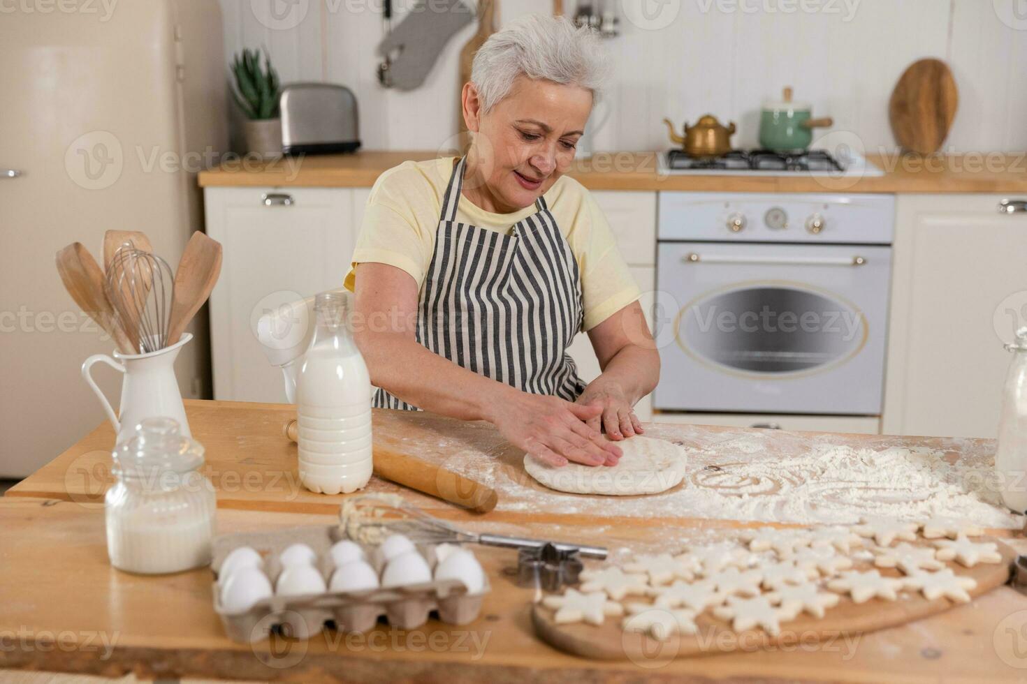 contento mayor mujer Cocinando en cocina. elegante más viejo maduro gris peludo dama abuela amasar masa hornear galletas. antiguo abuela cocinar hecho en casa alimento. casa ama de casa tareas del hogar concepto. foto