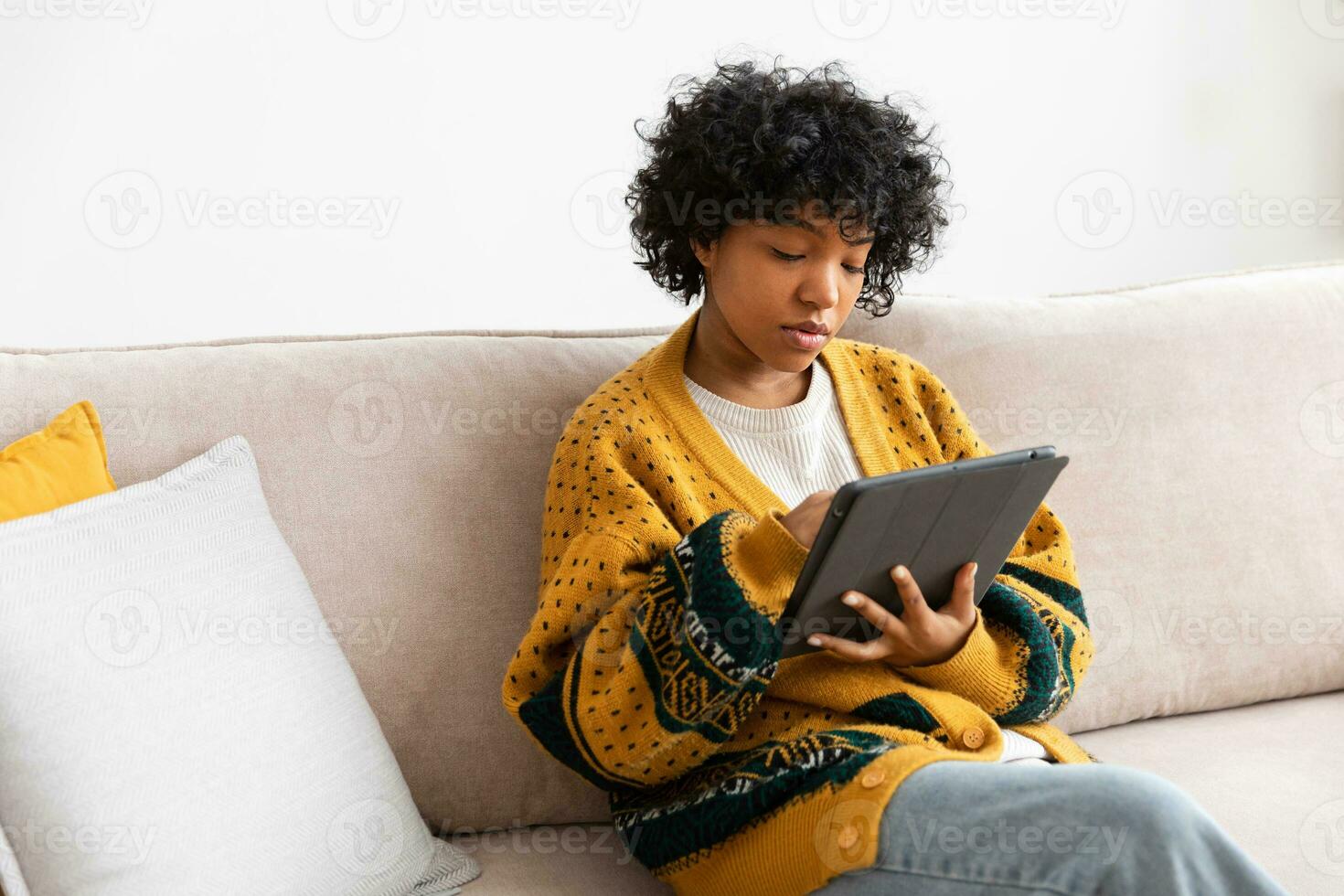 African american girl holding digital tablet touch screen typing scroll page at home. Woman with mobile tech device surfing internet using social media apps playing game. Study work shopping online. photo