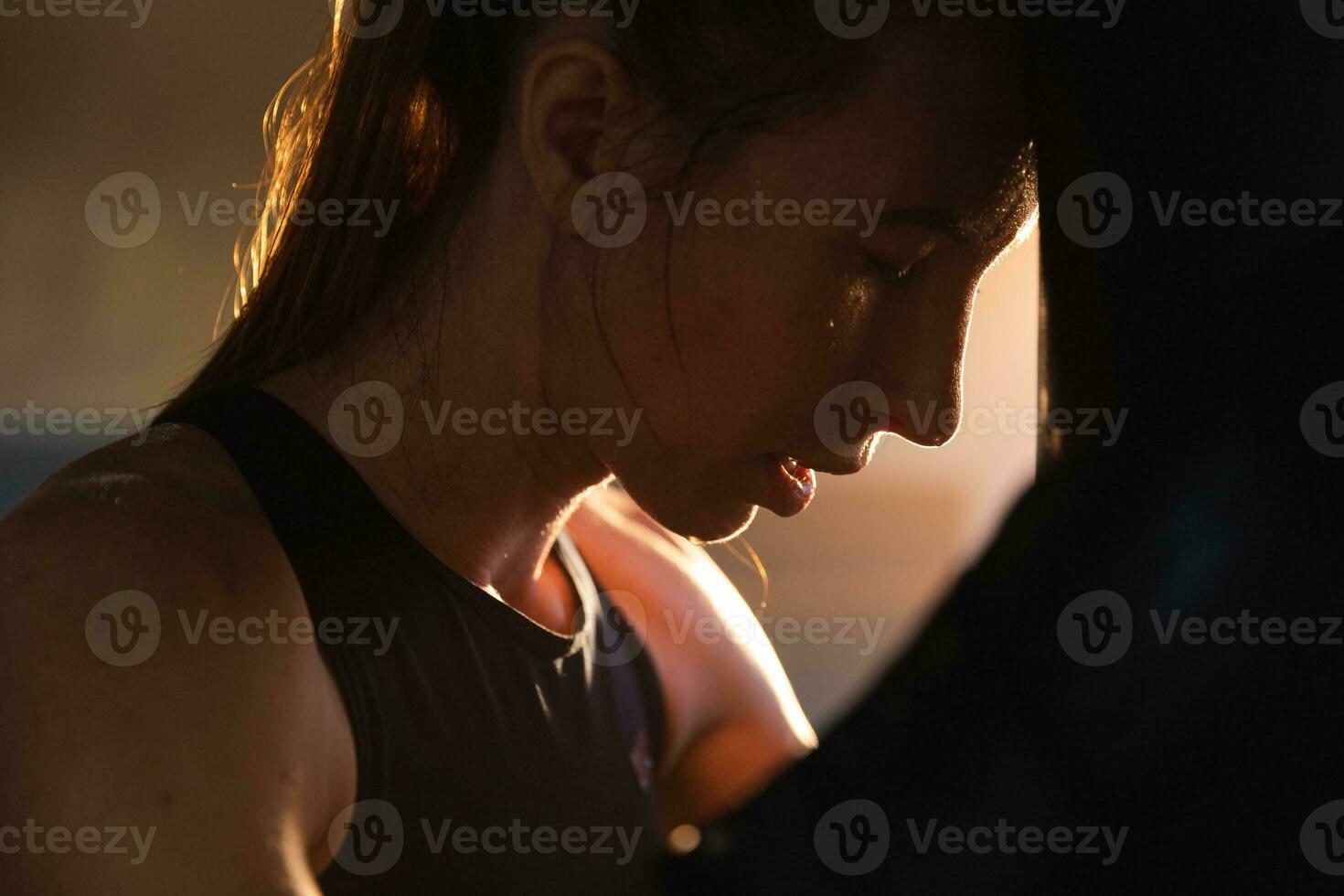 mujer yo defensa niña fuerza. fuerte mujer combatiente descansando después lucha formación en boxeo anillo. fuerte niña cansado después puñetazos boxeo bolsa. formación día en gimnasia. fuerza ajuste cuerpo rutina de ejercicio capacitación. foto