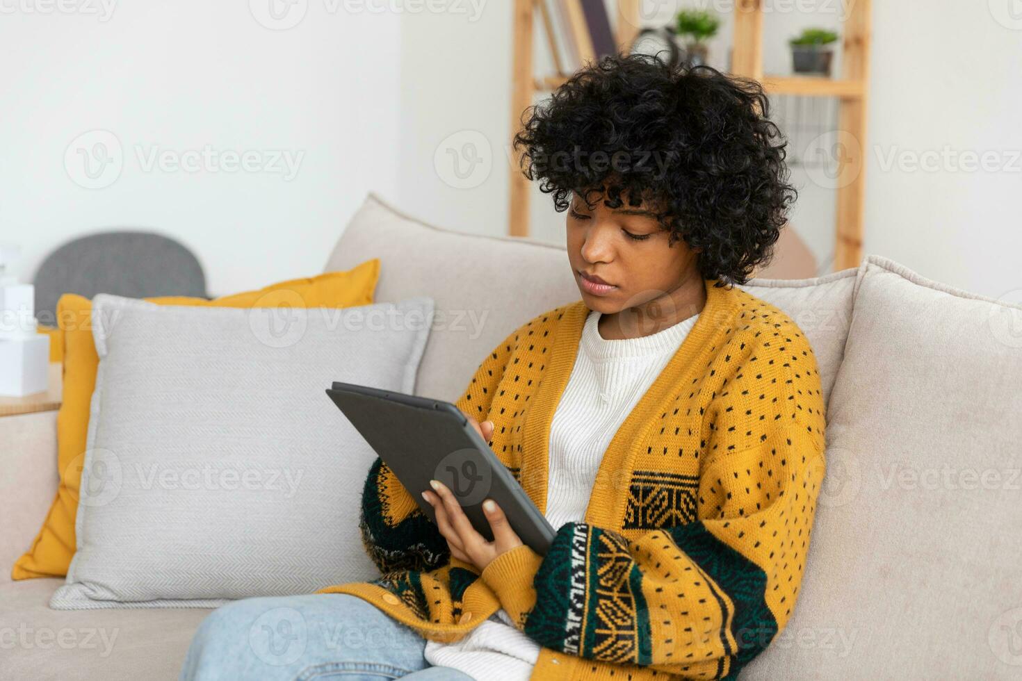 African american girl holding digital tablet touch screen typing scroll page at home. Woman with mobile tech device surfing internet using social media apps playing game. Study work shopping online. photo