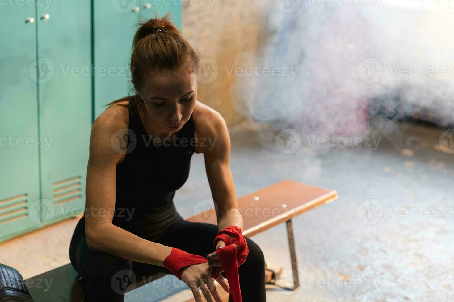 mujer yo defensa niña fuerza. mujer combatiente preparando para lucha envase manos con rojo boxeo envuelve Deportes protector vendajes fuerte niña Listo para lucha activo ejercicio combate rutina de ejercicio capacitación. foto