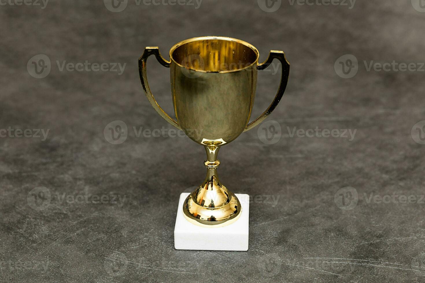 simplemente diseño ganador o campeón oro trofeo taza en hormigón Roca gris antecedentes. victoria primero sitio de competencia. victorioso o éxito concepto. parte superior ver Copiar espacio. foto