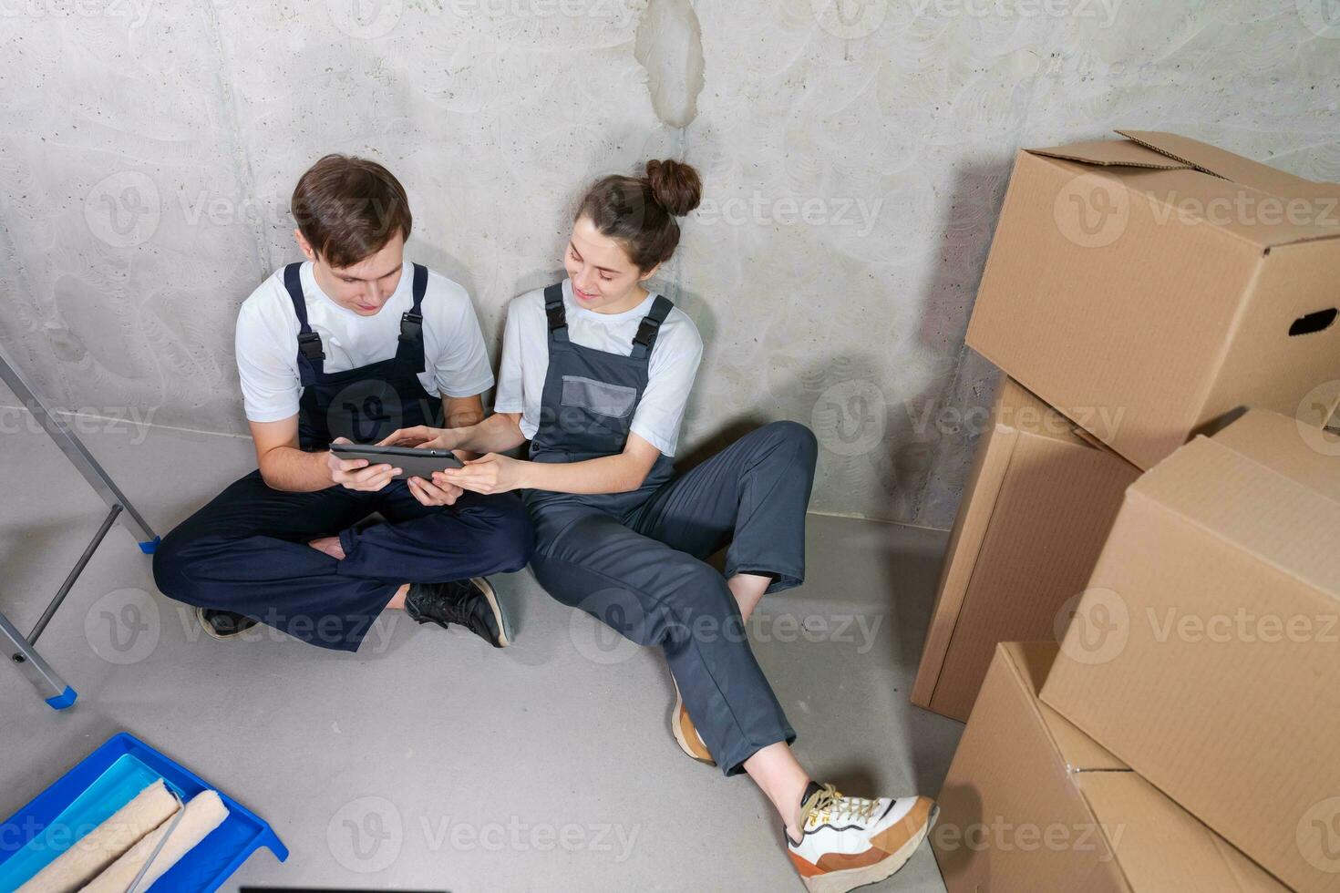 Couple in new home during repair works discussing about home design project looking repair plan on tablet. Happy family choosing new decorations and design. Home renovation DIY renew makeover concept. photo