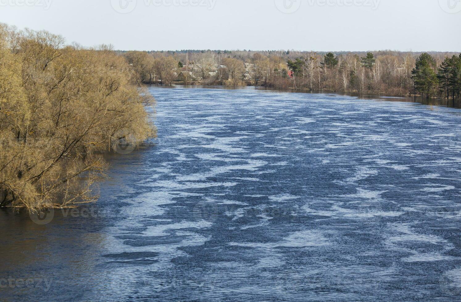 Floods in the spring forest. Sunny spring day and blue sky. Waves on the water. View from above. Photo in high quality. Horizontal
