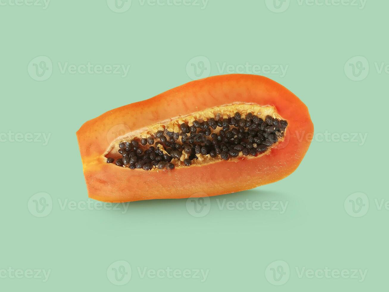 Half of ripe papaya fruit with seeds on a color background. Appetizing tropical fruit photo