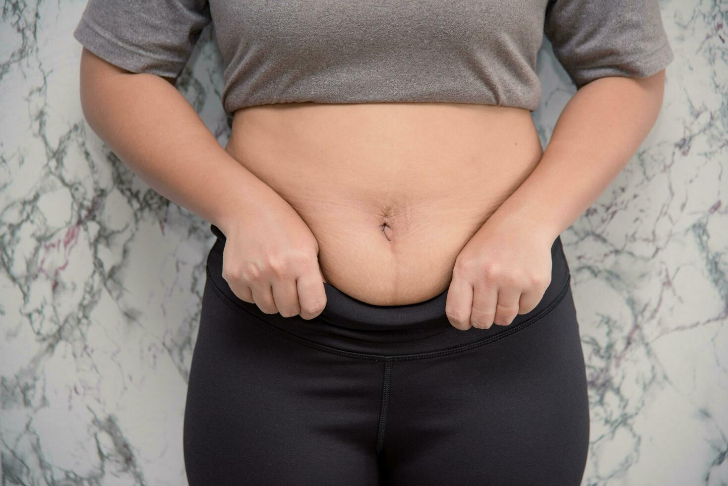 woman touching his belly on white background , fat photo